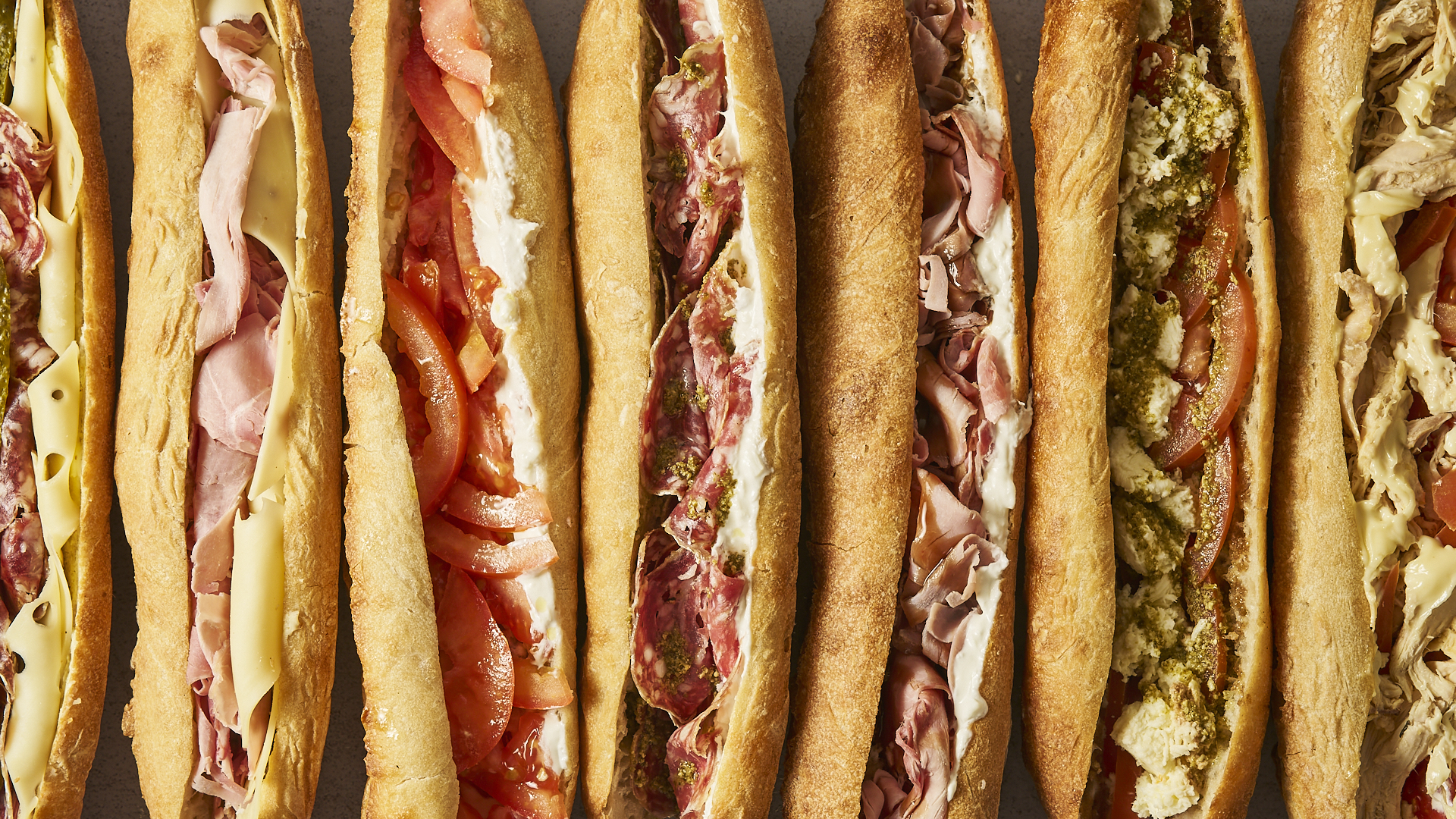 Sept baguettes BBT alignées : saucisson, jambon, tomates stracciatella, bresaola, poulet fermier
